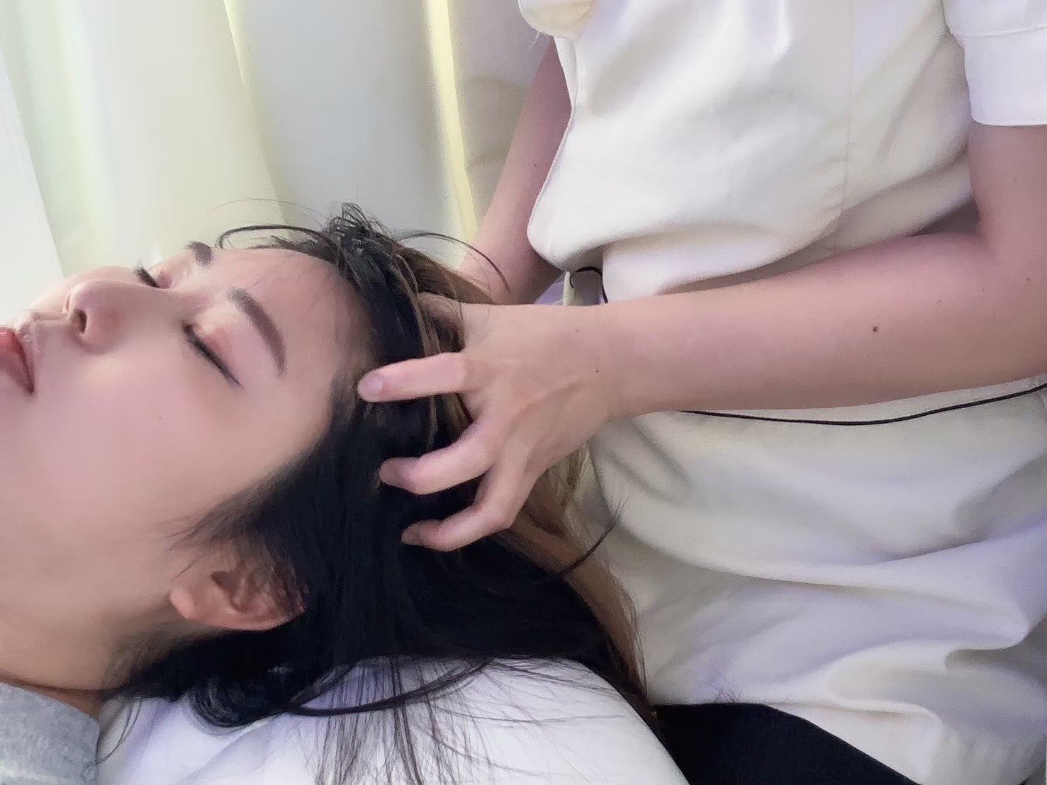 頭まわりへ手を添えて施術する様子